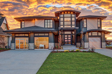 Large contemporary gray two-story stucco exterior home idea in Calgary