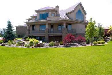 Пример оригинального дизайна: большой, двухэтажный, бежевый дом в современном стиле с облицовкой из цементной штукатурки и двускатной крышей