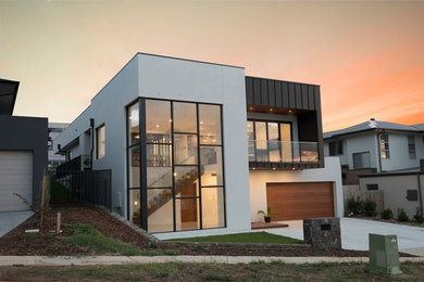 Diseño de fachada de casa blanca actual grande de dos plantas con revestimientos combinados y tejado plano