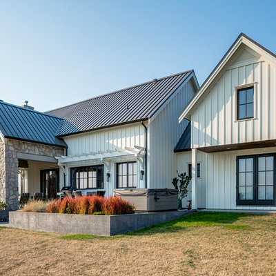 Example of a large cottage white two-story concrete fiberboard exterior home design in Vancouver with a metal roof