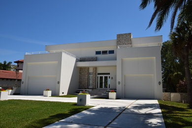 Example of a mid-sized trendy white two-story stucco exterior home design in Tampa