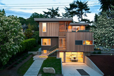 Trendy brown split-level wood flat roof photo in Vancouver