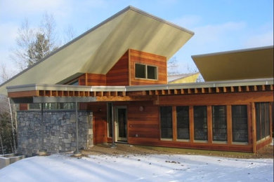 Contemporary brown three-story wood exterior home idea in Other with a clipped gable roof