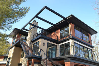 Foto de fachada de casa beige actual grande de tres plantas con revestimientos combinados, tejado plano y tejado de metal
