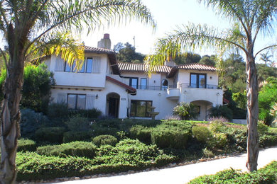 Example of a large tuscan beige two-story stucco gable roof design in Santa Barbara