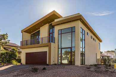 Ejemplo de fachada beige contemporánea de tamaño medio de dos plantas con revestimiento de estuco y tejado plano