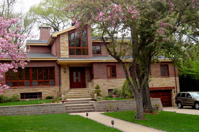 Imagen de fachada de casa beige y gris actual grande de dos plantas con revestimientos combinados, tejado a dos aguas y tejado de teja de madera
