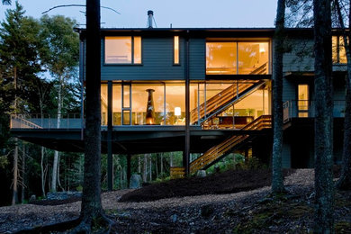 Diseño de fachada beige de tamaño medio de dos plantas con revestimiento de madera y tejado a dos aguas