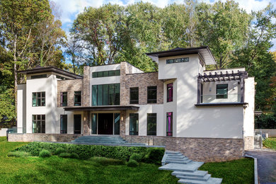 Foto de fachada de casa beige actual de tres plantas con revestimiento de estuco y tejado plano