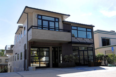 Example of a mid-sized trendy beige two-story concrete flat roof design in Los Angeles