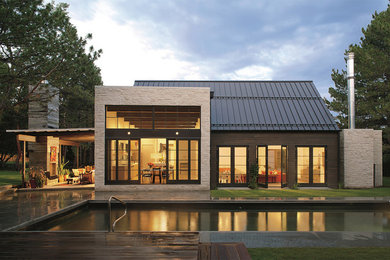 Modelo de fachada beige contemporánea grande de una planta con revestimientos combinados y tejado a dos aguas