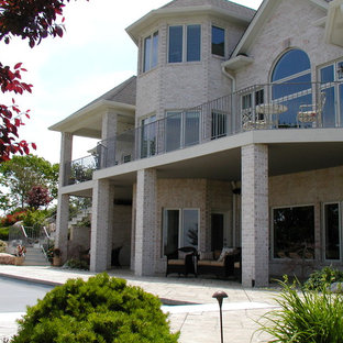 Inspiration for a large timeless gray three-story brick gable roof remodel in Indianapolis