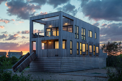 Modelo de fachada de casa gris contemporánea de tamaño medio de dos plantas con revestimiento de madera y tejado plano