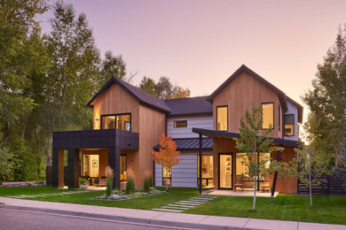 Imagen de fachada de casa marrón contemporánea de tamaño medio de dos plantas con revestimientos combinados, tejado a dos aguas y tejado de varios materiales
