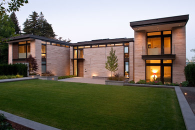 Ejemplo de fachada beige moderna de dos plantas con revestimiento de piedra y tejado plano