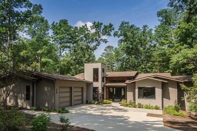 Example of a mid-sized trendy brown two-story concrete fiberboard house exterior design in Other with a clipped gable roof and a shingle roof