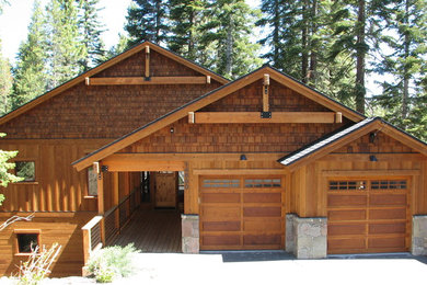 Cette photo montre une grande façade de maison marron tendance en bois à un étage avec un toit à deux pans et un toit en shingle.