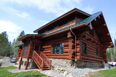 Foto de fachada de casa marrón rural de tamaño medio de dos plantas con revestimiento de madera, tejado a dos aguas y tejado de teja de madera