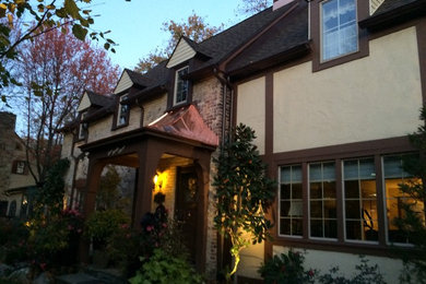 Diseño de fachada de casa beige clásica de tamaño medio de dos plantas con revestimiento de ladrillo, tejado a dos aguas y tejado de teja de madera
