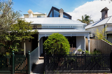 Imagen de fachada de casa blanca actual pequeña de dos plantas con revestimiento de madera, tejado a dos aguas y tejado de metal