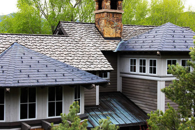 Modelo de fachada de casa gris tradicional grande de dos plantas con revestimientos combinados, tejado a dos aguas y tejado de teja de barro
