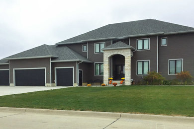 Transitional gray two-story vinyl exterior home photo in Cedar Rapids with a hip roof