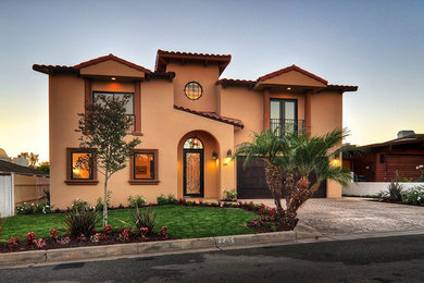 Large tuscan beige two-story stucco house exterior photo in Los Angeles with a hip roof and a tile roof