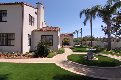Example of a huge tuscan beige two-story stucco exterior home design in San Diego with a tile roof