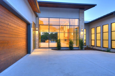 Example of a large trendy one-story stucco exterior home design in Austin