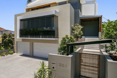 Ejemplo de fachada de casa beige contemporánea grande de tres plantas con revestimiento de hormigón y tejado de metal