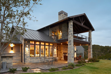 Example of a mid-sized transitional gray two-story stone gable roof design in Austin