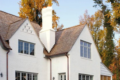 Diseño de fachada de casa blanca clásica de dos plantas con revestimiento de ladrillo y tejado a dos aguas