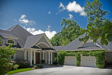 Example of a large classic gray three-story wood exterior home design in Raleigh with a hip roof