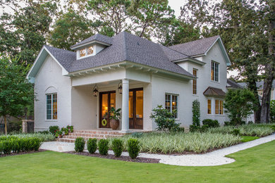 Photo of a white traditional two floor brick house exterior in Other with a pitched roof.