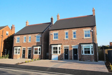 Medium sized modern brick terraced house in Other with a pitched roof and a tiled roof.
