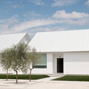 Ispirazione per la facciata di una casa bianca contemporanea a un piano di medie dimensioni con tetto a capanna, rivestimento in vinile e tetto bianco