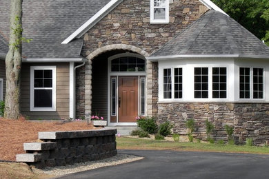Imagen de fachada gris tradicional de tamaño medio con revestimiento de piedra y tejado a dos aguas