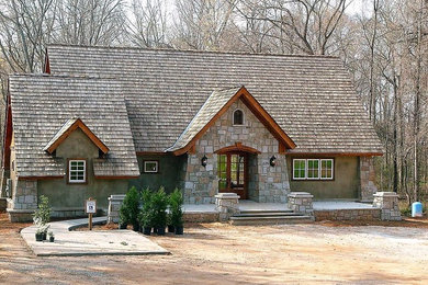 Ejemplo de fachada de casa rural de dos plantas con revestimientos combinados, tejado a dos aguas y tejado de teja de madera