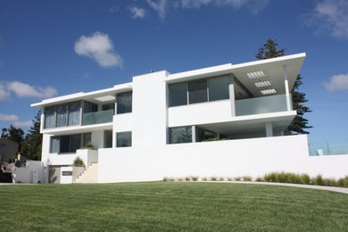 Ejemplo de fachada blanca moderna de tres plantas con tejado plano