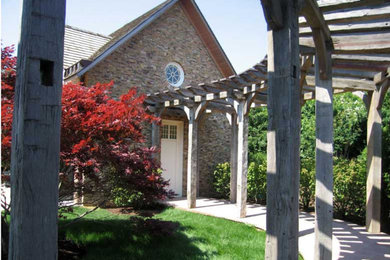 Diseño de fachada beige de estilo americano de tamaño medio de dos plantas con revestimiento de piedra y tejado a dos aguas