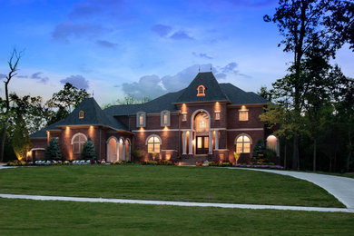 Huge french country red two-story brick house exterior photo in Cincinnati with a hip roof and a shingle roof