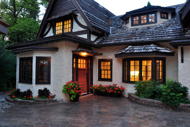 Imagen de fachada blanca tradicional grande de dos plantas con revestimiento de estuco y tejado a dos aguas