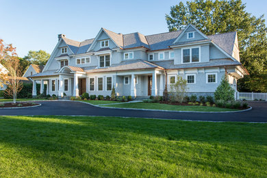 На фото: большой, двухэтажный, деревянный, синий дом в классическом стиле с двускатной крышей