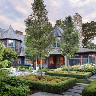Cette image montre une grand façade en bois marron traditionnelle à un étage avec un toit de Gambrel.