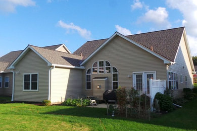 Inspiration for a mid-sized timeless beige one-story vinyl gable roof remodel in Cleveland
