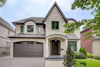 Beige two-story stone exterior home idea in Toronto with a shingle roof