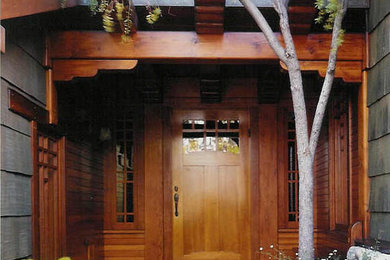 Foto della villa grande marrone american style a due piani con rivestimento in legno, tetto a capanna e copertura a scandole