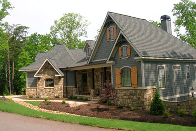 Modelo de fachada de casa azul de estilo americano de tamaño medio de dos plantas con revestimientos combinados, tejado a cuatro aguas y tejado de teja de madera