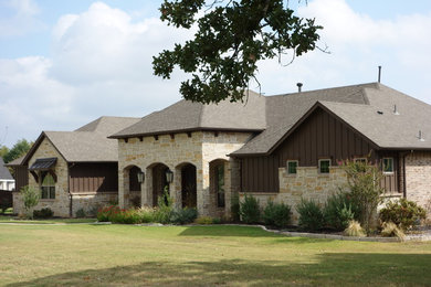 Diseño de fachada de casa beige de estilo americano de tamaño medio de dos plantas con revestimientos combinados, tejado a cuatro aguas y tejado de teja de madera