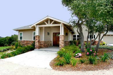 Example of a mid-sized arts and crafts beige two-story vinyl house exterior design in San Luis Obispo with a hip roof and a shingle roof